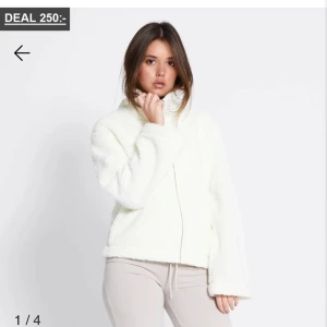 Vit teddyjacka från lager 157 - Mysig vit teddyjacka med dragkedja framtill. Jackan har en avslappnad passform och långa ärmar, perfekt för kyliga dagar. Den fluffiga texturen ger en trendig look. Storlek xs aldrig använt helt ny