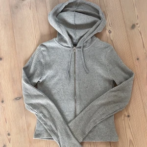Grå ribbad hoodie från Gina Tricot - säljer denna zip hoodien från gina då den inte kommer till användning längre 💞 fint skick, inga defekter, nypris 399kr!