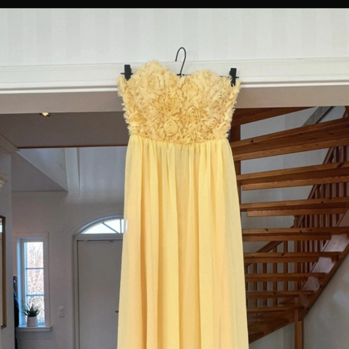 Gul axelbandslös klänning med blommig detalj