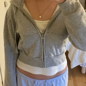 Grå hoodie från Brandy Melville - Mysig cropped hoodie från brandy! Inga defekter men kommer ej till användning längre, så mysig att bara ha hemma eller ute ❤️