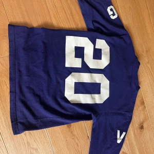 Blå långärmad t-shirt från Ben-G - Säljer en blå långärmad t-shirt från Ben-G med stora vita siffror '05' på framsidan och '05' på baksidan. Ärmarna har också vita detaljer. Perfekt för en avslappnad stil.