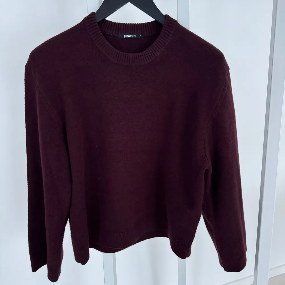Snygg vinröd/ Burgbuny stickad tröja från Gina Tricot. Strl medium. Tröjan har långa ärmar och en klassisk rund halsringning. Ett måste i garderoben för en stilren look. Använd kanske 5 gånger så är i väldigt fint skick, men skriver att någon noppa kan finnas. Djur och rökfritt hem . Neuletakit & Villapaidat.