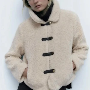  teddyjacka från Zara -  beige teddyjacka från Zara med svarta knappar. Jackan ör knappt använd och i nyskick!