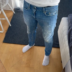Dondup jeans med slitningar - Säljer nu mina riktigt snygga blå jeans från dondup med riktigt sköna slitningar. OBS inga hål bara slitnignar som är menat att vara där! De har en klassisk femficksdesign och en knappgylf. Perfekta för en avslappnad stil. Nypris ca 3500kr🌟 Tyvärr har lappen med storlek åkt av (sista bilden) men skulle säga att de sitter som mellan W 28-W30 Skriv vid funderingar😁