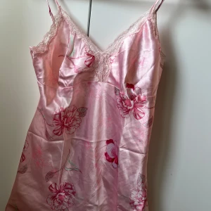 Rosa blommig nattlinne från O'Malley - Säljer ett vackert rosa nattlinne från O'Malley med blommigt mönster och spetsdetaljer. Tillverkat i ett glansigt material med justerbara axelband och v-ringad design💞priset är utifrån vad liknande klänningar säljs för 