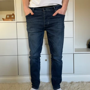 Mörkblå jeans från Neuw - Snygga mörkblå jeans från Neuw med en klassisk femficksdesign. De har en modern tapered passform och är tillverkade i ett slitstarkt denimtyg. Perfekta för en stilren look. Model ray tapered 