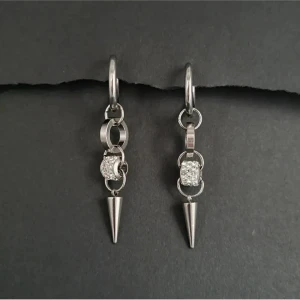 Silvriga örhängen med spetsdetalj - Snygga silvriga örhängen med en unik design. De har en kedja med glittriga detaljer och avslutas med en spetsig hängande del. Perfekta för att ge en edgy touch till din stil.Unika handgjorda örhängen ● 💎Material- rostfritt stål, zirconia ● Örhängeskrokar-  Rostfritt stål. Längd-6cm 