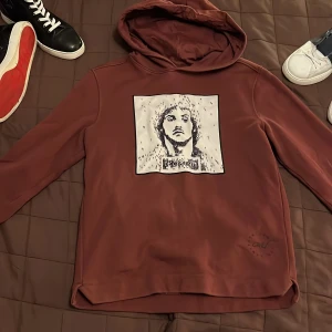 hoodie från Limitato - Säljer en vinröd hoodie från Limitato i 100% bomull. Den har en unik tryckdetalj på framsidan med en konstnärlig design. Perfekt för en avslappnad stil med en touch av konstnärlig flair. nypris ligger den på 2100