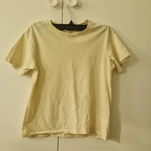 Ljusgul t-shirt från KappAhl - En enkel ljusgul t-shirt från KappAhl. I storlek 146/152 för barn. 