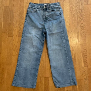 Blå wide jeans med hög midja - Snygga blå jeans med breda ben och klassisk femficksdesign. Modellen har hög midja och raka, vida ben. 
