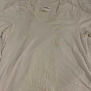 Vit v-ringad t-shirt från Selected Femme - Vit t-shirt från Selected Femme med snygg v-ringning och korta ärmar. Tillverkad i mjuk bomull som känns skön mot huden. Enkel och clean design som funkar till allt, perfekt för dig som gillar minimalistisk stil.