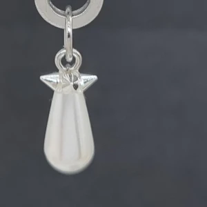 Silverörhänge med vit pärldroppe - Stilrent örhänge i silver med en droppformad vit pärla som hänger från en liten metallögla. Perfekt för dig som gillar minimalistiska smycken med en elegant touch. Passar till alla tillfällen och ger en fräsch vibe till din look.