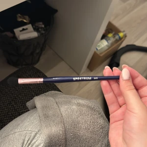 Spectrum ögonskuggsborste A16 - Snygg ögonskuggsborste från Spectrum i modellen A16. Borsten har ett mörkblått skaft med roséguldfärgad metall och mjuka svarta borststrån. Perfekt för att blenda och applicera ögonskugga med precision.