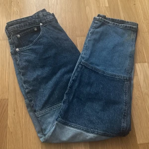 H&M blå jeans med raka ben - Säljer ett par H&M divided jeans i flerfärgad denim. Modellen har raka ben och fem silver knappar. Perfekta för dig som gillar retro och streetstyle. Ifall ni har frågor eller vill ha flera bilder är det bara att höra av sig💗💗💗