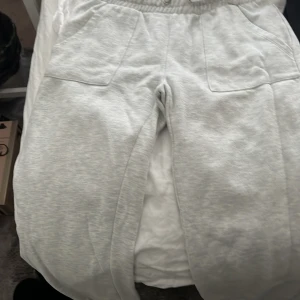 Grå mjukisbyxor från 157, storlek S - Säljer ett par ljusgrå mjukisbyxor från 157 i storlek S. Byxorna har bred resår i midjan och två stora fickor framtill. Perfekta för chill eller träning, riktigt sköna och mjuka med loose passform.