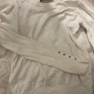 Stickad tröja  - Fin och fina detaljer men har 2 fläckar.