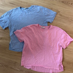 Rosa och blå t-shirt från Zara - Två basic t-shirts i skön bomull, en i ljusrosa och en i ljusblå. Båda har rund hals och korta ärmar, perfekt för chill dagar. Båda från Zara och har en loose passform med lite längre bakstycke. Snygga att matcha med jeans eller shorts.