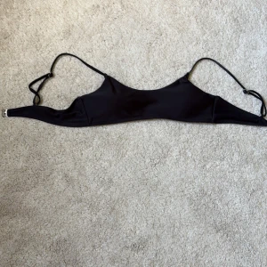 Svart bikiniöverdel med justerbara band - Svart bikiniöverdel i stilren design med smala, justerbara axelband och enkel knäppning bak. Materialet är mjukt och stretchigt, däremot har resonen försämrats genom åren men den funkar ändå!🤗