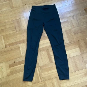 Svarta leggings från SOC i storlek S - Säljer ett par svarta leggings från SOC i storlek S. De har en hög midja och är tillverkade i ett stretchigt syntetmaterial som sitter tight och bekvämt. Perfekta för träning eller chill dagar. Snygg, enkel design utan synliga detaljer.