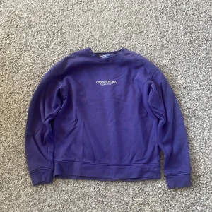 Lila sweatshirt från Jack & Jones - Bra skick.Säljer en lila sweatshirt från Jack & Jones med trycket 'Originals Studio' på bröstet. Tröjan har rund hals, långa ärmar och en relaxed passform. Perfekt för chill dagar och enkel att matcha med jeans eller joggers.