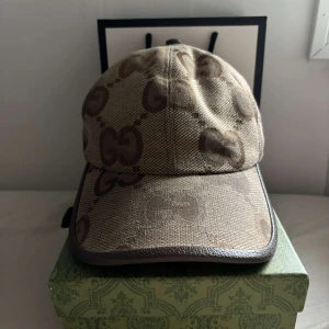Beige keps från Gucci med GG-mönster - Säljer en beige keps från Gucci, pris kan diskuteras vid snabb affär. Kepsen är använd ett par gånger. Kepsen är köpt i Gucci affären i Köpenhamns flygplats. Bild på kvittot finns, nypris 5850 :-  kepsen tillverkas inte längre. Dessutom perfekt för dig som vill ha en lyxig och stilren accessoar med tydlig designer-vibe.