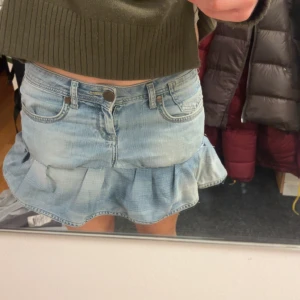 lågmidjad jeanskjol med volang - aaassss snygg och passar till massor! skulle säga att den sitter som en st S/M lite små skavanker vid volangen vilket visas på bilderna men fortfarande jätte fin pris kan diskuteras