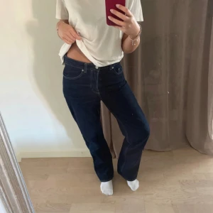 Mörkblå jeans från Weekday - Snygga mörkblå jeans från Weekday med en klassisk straight passform. De har en normal midja och är perfekta för en avslappnad stil. Jeansen har fem fickor och stängs med knappar. Det kommer tyvärr inte till användning. Passar mig som har storlek 36