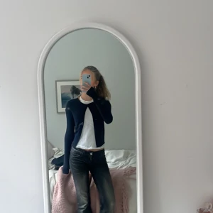 Mörkblå kofta från Gina Tricot - Säljer en mörkblå kofta från Gina Tricot. Koftan har långa ärmar och en enkel design som passar perfekt till olika outfits. Perfekt för både vardag och mer uppklädda tillfällen. Och om man vill ha någon fin topp men även ha lite tecknande💞