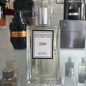 Parfym 290 från The Essence Vault - Säljer en elegant parfym från The Essence Vault, nummer 290. Flaskan är rektangulär och genomskinlig med en stilren etikett. Den har en silverfärgad spraypump och rymmer 100 ml av doften. Perfekt för den som söker en sofistikerad och tidlös doft.