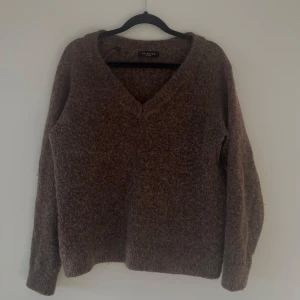 Brun stickad tröja från Selected Femme - Mysig brun stickad tröja från Selected femme  med v-ringning. Perfekt för kyliga dagar med sin mjuka och bekväma passform. Tröjan har långa ärmar och ribbade kanter.