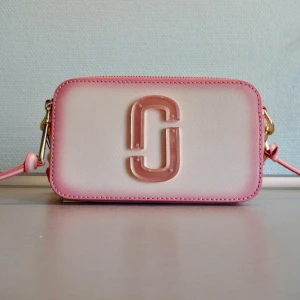 Marc Jacobs Women's Snapshot Fluoro Edge Camera Bag in Peach - The bag is made of 100% cow leather.   The webbing bag strap is removable and adjustable.   Two zip closures.   One card slot on the back of the bag.  Dimensions : 18 x 11 x 6 cm   The bag has never been worn. The tag is still attached to the bag.   The bag will be delivered together with the original dust bag and the box.  Please note that there is a very small mark inside the logo, see the picture. 
