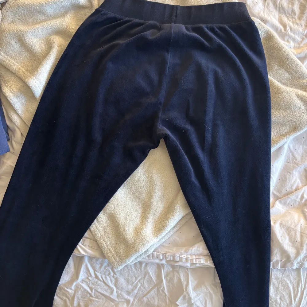 Säljer ett par mörkblå mjukisbyxor från Juicy Couture. Byxorna har en bekväm passform med snörning i midjan och är tillverkade i ett mjukt material. Perfekta för en avslappnad stil. 💞. Farkut & Housut.