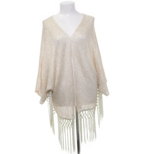 Beige glittrig kofta med fransar från Angela - Mycket fint skick! Säljer en elegant beige/off white kofta från Angela med glittrande detaljer och fransar. Den har en v-ringad design och är tillverkad i en blandning av akryl och polyester. Perfekt för att lägga till lite glamour till din outfit. Använd några få gånger, inte tvättad utan vädras ordentligt. Fler bilder kan fås vid intresse.