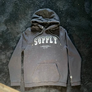 Svart Supply & Demand Hoodie - Säljer min svart hoodie från Supply & Demand. Det är en klassiker men väldigt snygg. Normal passform och perfekt till en avslappnad stil nu mot varmare väder!