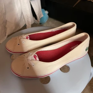 Ballerina skor Lacoste Sport - Ballerina skor som är lite beigea just nu i färgen men bara med en liten tvätt blir de säkert vita. Märket Lacoste Sport, vet ej om de fortfarande säljs☺️