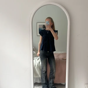 Mörkblå blus från meet me there - Säljer en söt mörkblå blus från meet me there med volangdetaljer på ärmarna. Blusen har en lös passform och ett fint broderat mönster. Perfekt för fina tillfällen🌌