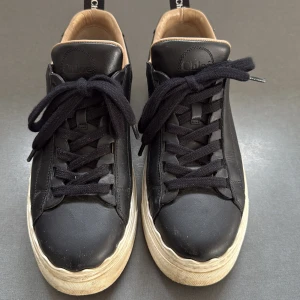 Svarta sneakers från Chloé - Snygga svarta sneakers från Chloé i skinn med svarta snören och en vit sula. 