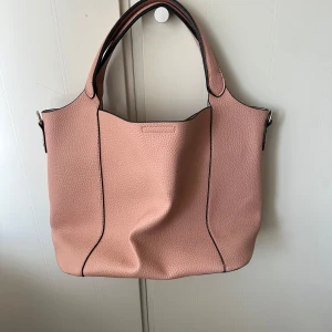 Väska - Superfin beige/rosa väska som är super rymlig!! Tillkommer en väska man kan ha i som ger flera fack så du enkelt hittar allting, eller om man vill använda den som något annat💞I botten på väskan är det små svarta märken som tyvärr inte går bort men inget som syns vid användning💞Vet tyvärr inte vart den kommer ifrån!!