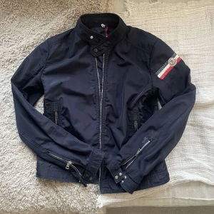 Moncler jacka - Priset går att diskutera | Snygg vindjacka från Moncler med dragkedja och knappar. Den har en cool detalj med Moncler-loggan på ärmen och en hög krage | skriv om du har frågor!