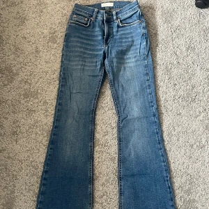 Blå lågmidjade bootcut jeans 32 - Snygga blå lågmidjade bootcut jeans med klassisk femficksdesign. Perfekta för en avslappnad stil. De har en knapp och dragkedja framtill. Från Gina Tricot i storlek 32 