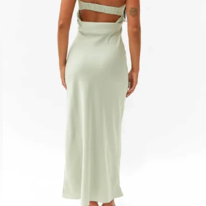 Ljusgrön axelbandslös klänning - Elegant ljusgrön axelbandslös klänning med en stilren design. Klänningen har en öppen rygg och en lång siluett som ger en sofistikerad look. Perfekt för balen! Med prislappen kvar!