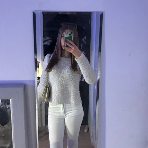 Vit fluffig tröja - Säljer en supermjuk och fluffig vit tröja med lång ärm. Perfekt för att hålla sig varm och stilren under kyligare dagar. Tröjan har en enkel design som gör den lätt att matcha med olika outfits.