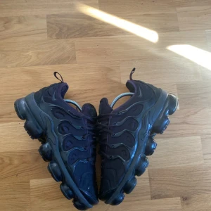 Svarta Nike sneakers - Säljer ett par Nike Air Vapormax Plus "Triple Black" i storlek US 7 (EUR 40). Skorna är i fint skick, använda väldigt sparsamt och alltid vårdade. Väldigt bekväma med den ikoniska Vapormax-sulan som ger skön dämpning. Perfekta för både vardagsbruk och träning. En tidlös modell som passar till allt – sneakers för dig som vill kombinera stil och komfort!  Nypris: ca 2500 kr – mitt pris: [1000 kr] Först till kvarn! Skicka PM vid intresse. 