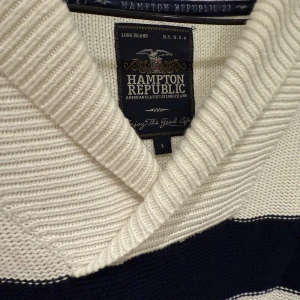 Vit och marinblå randig stickad tröja från Hampton Republic - Säljer en stickad tröja från Hampton Republic i vitt med marinblåa horisontella ränder. Tröjan har en bred krage och långa ärmar. Perfekt för en klassisk och avslappnad stil.