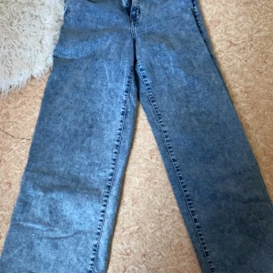 Blå raka jeans  - Säljer ett par klassiska blå jeans från Happy Holly med rak passform. Jeansen har en tidlös design och är tillverkade i denim med normal midja. Perfekta att matcha med olika toppar för en enkel och snygg look.