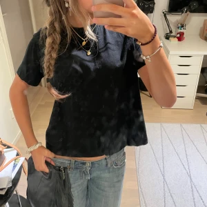 Svart t-shirt - En enkel svart croppad t-shirt med rund halsringning. T-shirten har korta ärmar och är tillverkad i ett mjukt material som passar perfekt till jeans eller kjol. I storlek M men funkar för mig som vanligtvis bär XS💘💘
