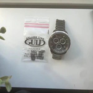 Silverfärgad herrklocka från Tissot utan extra delar - Säljer en stilren herrklocka från Tissot i silverfärgat rostfritt stål. Klockan har svart urtavla med tre mindre subdials och tydliga markeringar. Länkarmband i metall och klassisk design.