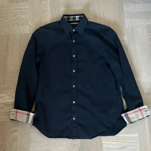 Svart burberry skjorta - Säljer nu denna svarta Burberry skjortan i storlek M. Den är i bra skick och perfekt nu inför sommaren! Nypris ca 5000kr. Hör av dig om du har funderingar! 🙌🏼