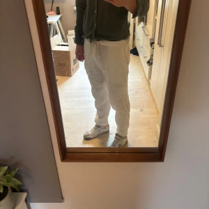 Vita linnebyxor med snörning - Säljer ett par vita linnebyxor från Zara med avslappnad passform och snörning i midjan. Byxorna har sidofickor och är perfekta för varma dagar. Lätta och luftiga, passar till en chill stil. Väldigt bra skick 10/10 knappt använda. Köptes för drygt 800kr.