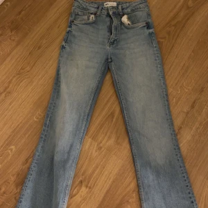 Ljusblå jeans från Zara - Säljer ett par ljusblå bootcut jeans fråm Zara. De är använda cirka 5 gånger. De är i storlek 32. De ser helt nya ut. Inga fläckar eller hål. Jag har inte klippt av de, de såldes så.